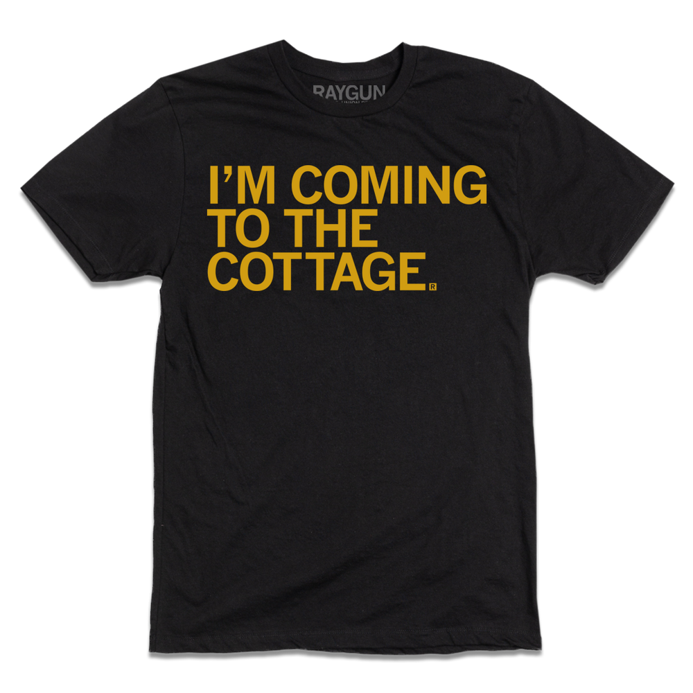 A black tee with left-aligned gold text that reads "I'm Coming To The Cottage"