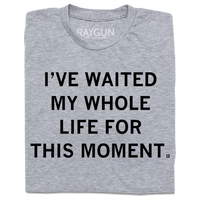 A folded heather grey t-shirt with centered black ink text that reads "I've waited my whole life for this moment."