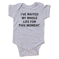A heather grey baby onesie with centered black ink text that reads "I've waited my whole life for this moment."