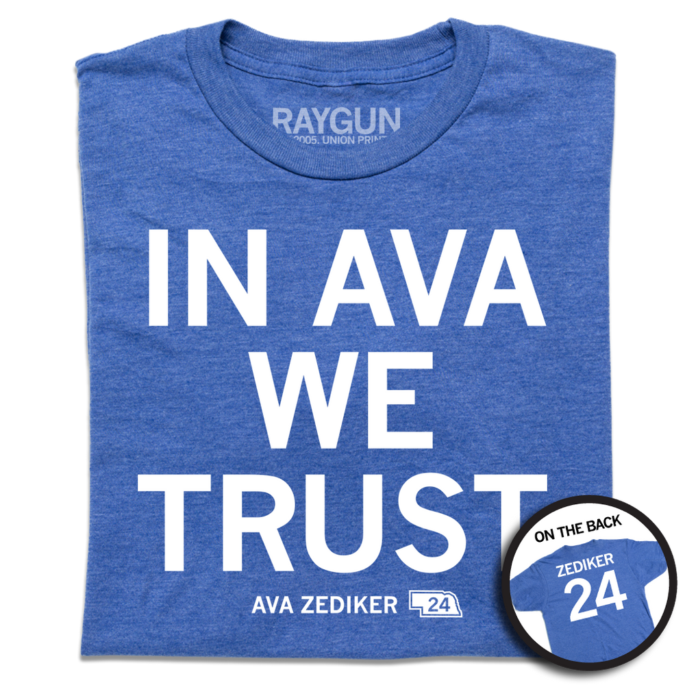 A folded heather royal blue shirt with stacked white ink text that reads "In Ava We Trust" over "Ava Zediker 24" in smaller font and a back print of "Zediker 24" styled like the back of a jersey.