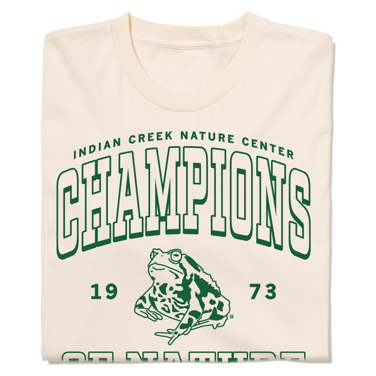 An off white t-shirt with kelly green ink that says, "Indian Creek Nature Center: Champions of Nature since 1973. Cedar Rapids, Iowa" with an illustration of a toad in the center.