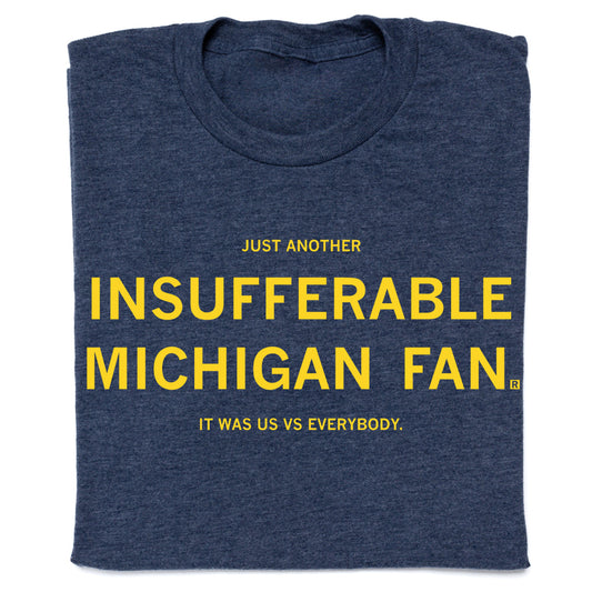 Navy blue RAYGUN t-shirt with yellow text that reads, Just another insufferable Michigan fan. It was us vs everybody.