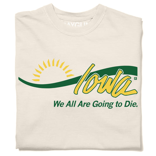 A folded cream t-shirt with yellow and green ink laid out like the welcome to Iowa sign with Joni Ernst's quote "We all are going to die" below.