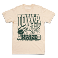Cream t-shirt with dark green ink that says, "Iowa: Prepare to be aMAIZEd by all this f*cking corn" along with an illustration of a cat riding a giant ear of corn.