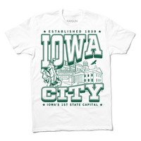 White tee with kelly green ink that says, "Iowa City: Established 1839. Iowa's first state Capital" with and illustrated Iowa City staples in the center, including the Englert Theater and the old Capitol Building.