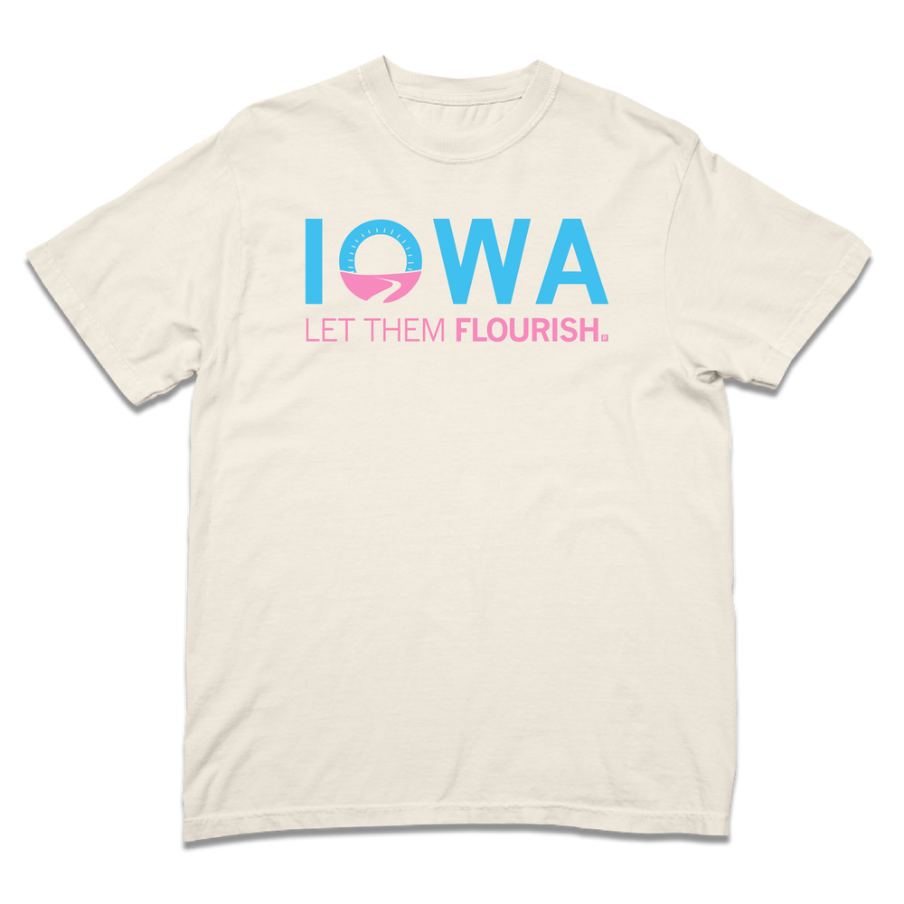 A folded heavyweight cream t-shirt with bright blue and pink print spoofing the Welcome to Iowa road signs by saying "Iowa Let Them Flourish."