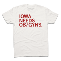 A dull white t-shirt with red left-aligned ink that reads "Iowa Needs OB/GYNs"