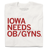 A folded off-white shirt with red left-aligned ink that reads "Iowa Needs OB/GYNs"