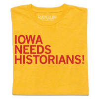 Folded gold shirt with bright red text that reads "Iowa Needs Historians!"