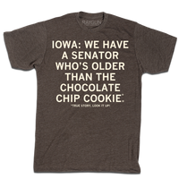 A heather brown tee with off white ink that says, "Iowa: We have a senator who's older than the chocolate chip cookie. True story, look it up!"