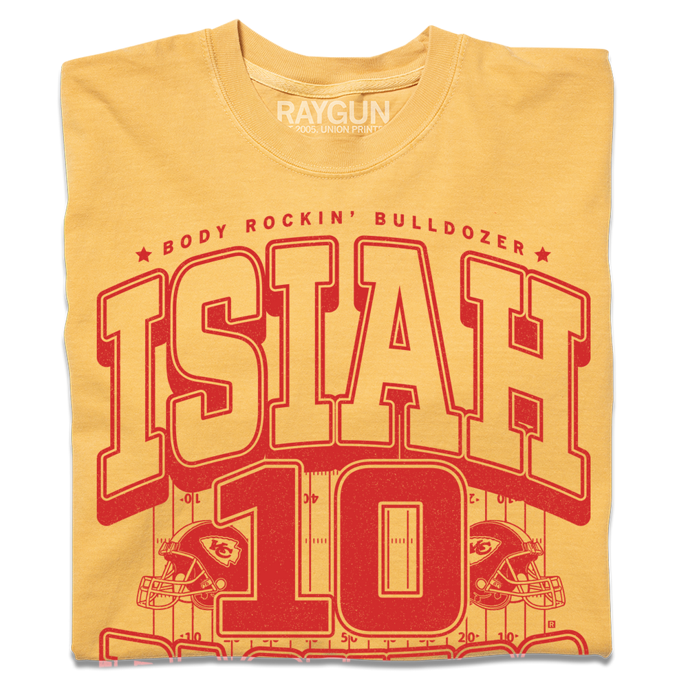Comfort Colors mustard t-shirt with red ink that reads "The Body Rockin' Bulldozer, Isiah Pachecho #10. The ground hates to see him running" over an illustration of a football field with a football helmet to either side.