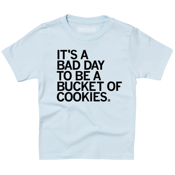 A light blue youth sized t-shirt with left aligned black text in all caps that says, "It's a bad day to be a bucket of cookies."