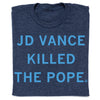 A heather denim t-shirt with the text JD VANCE KILLED THE POPE printed in light blue capital letters.