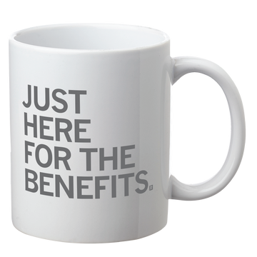 White dishwasher safe coffee mug with the grey text JUST HERE FOR THE BENEFITS. printed on the front.