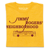 A folded heather mellow yellow shirt with cardinal ink that reads "Jimmy Rodger's Neighborhood" over an illustration of a bus with "Ames" printed on the side.