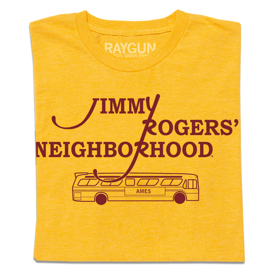 A folded heather mellow yellow shirt with cardinal ink that reads "Jimmy Rodger's Neighborhood" over an illustration of a bus with "Ames" printed on the side.