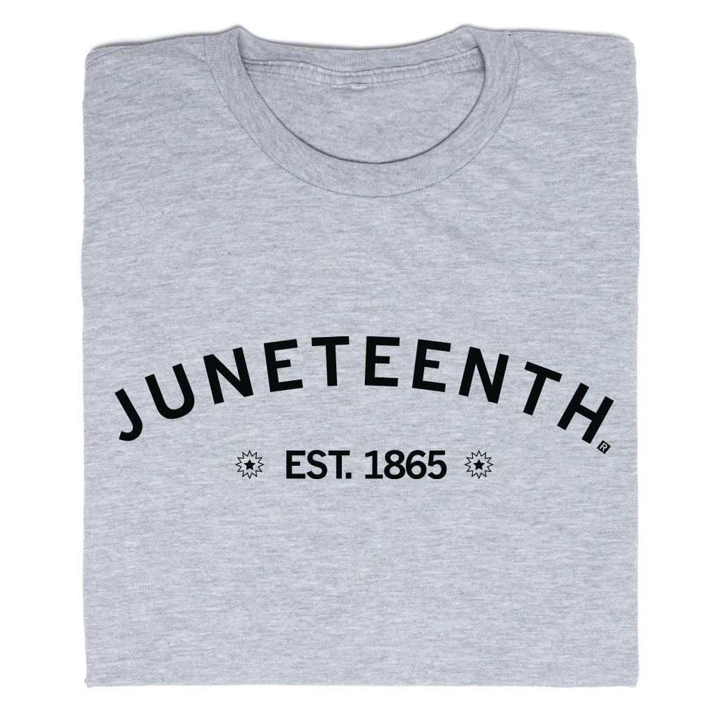 Folded grey RAYGUN crew-neck t-shirt with JUNETEENTH printed in a black arch above EST. 1865, flanked by starburst icons.