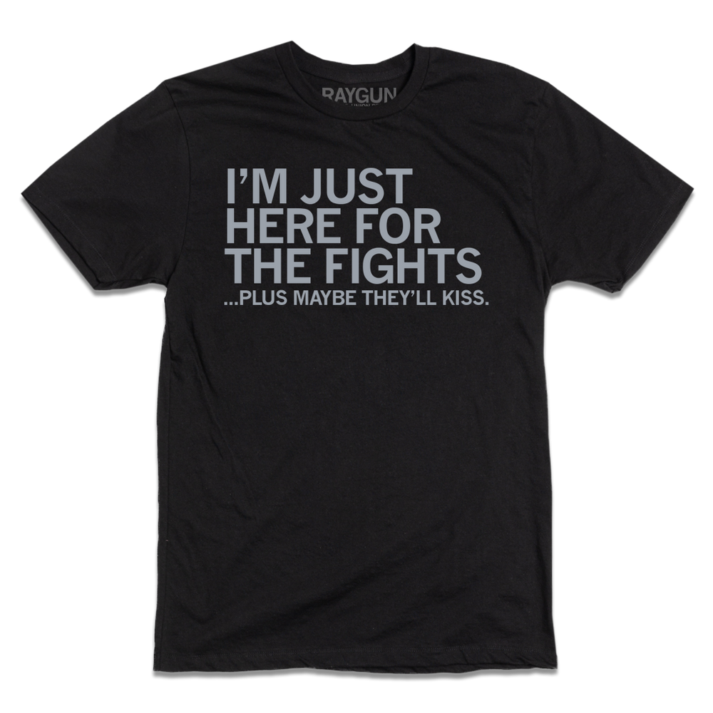 A black tee with light grey ink that says, "I'm just here for the fights...plus maybe they'll kiss"