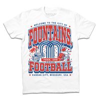 A white shirt with red and royal blue ink that says, "Welcome to the city of fountains, food, and football. Kansas City, Missouri USA" with a fountain, football, helmet, goalpost, smoker, and steak in the background.