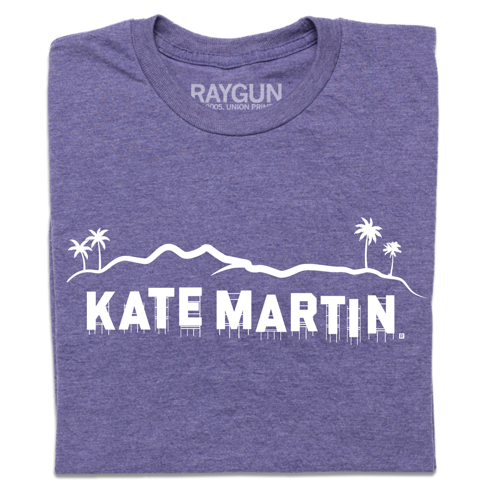A folded heather purple t-shirt with white screen print depicting the Hollywood sign as saying, "Kate Martin."