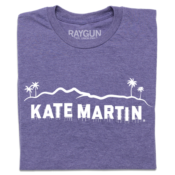 A folded heather purple t-shirt with white screen print depicting the Hollywood sign as saying, 
