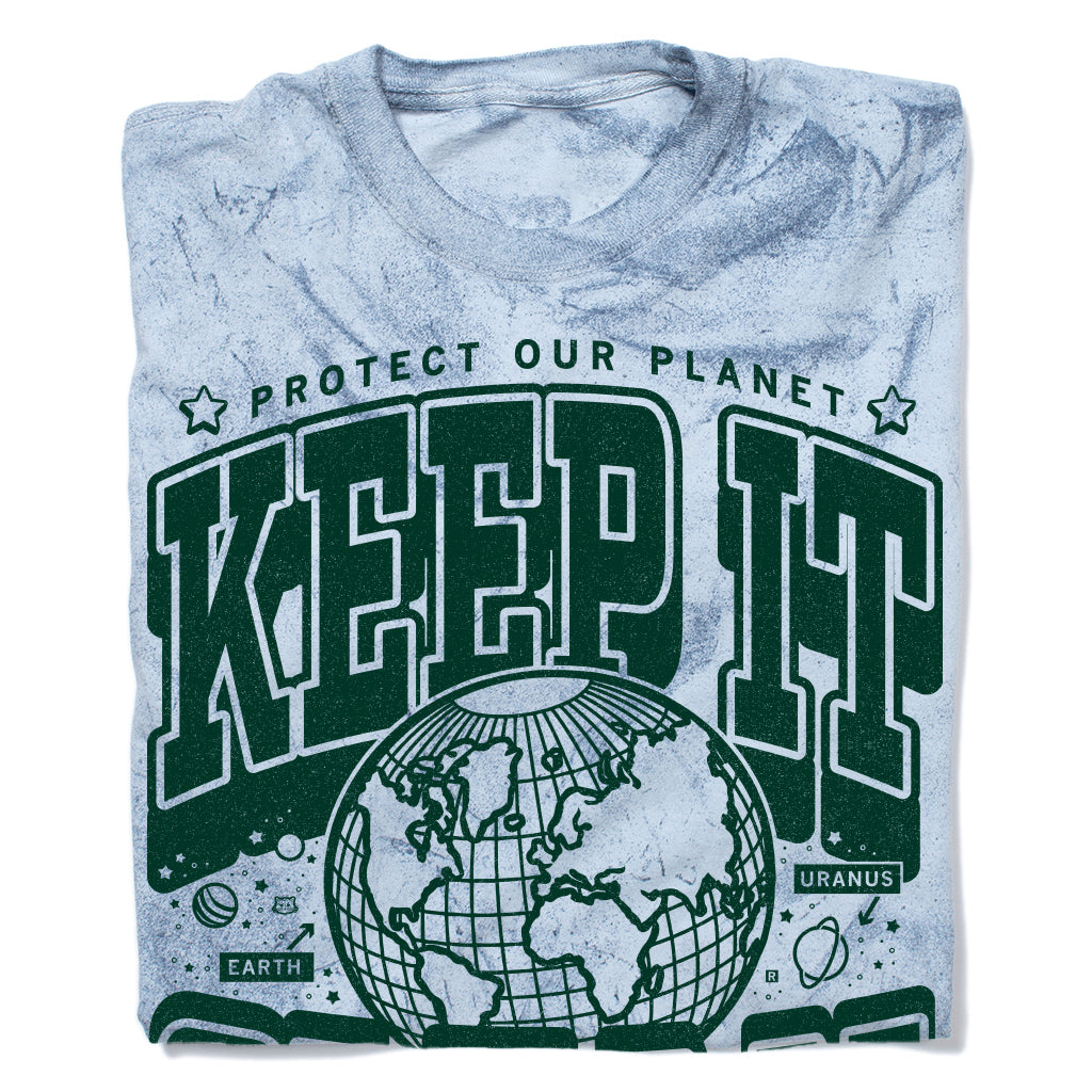 Light blue, garment-dyed, acid-wash collegiate t-shirt with a graphic that reads Protect Our Planet and Keep It in large green letters above a line drawing of Earth, with small illustrations of planets labeled Earth and Uranus.