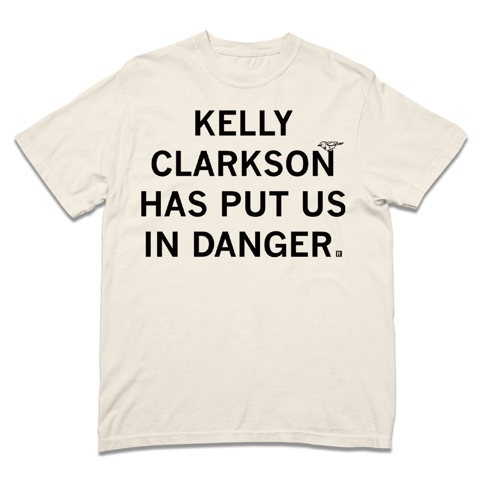 A Comfort Colors ivory heavyweight t-shirt with blank ink text that says, "Kelly Clarkson has put us in danger." with a little bird sitting on the N in "Clarkson."