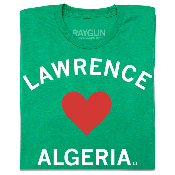 A folded heather green t-shirt with a red  heart in the center and white text that says, 
