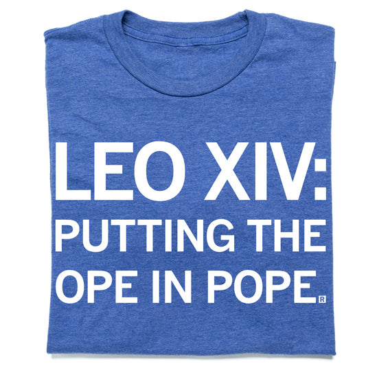Heather royal RAYGUN t-shirt featuring a blue design with white text that reads LEO XIV: PUTTING THE OPE IN POPE.