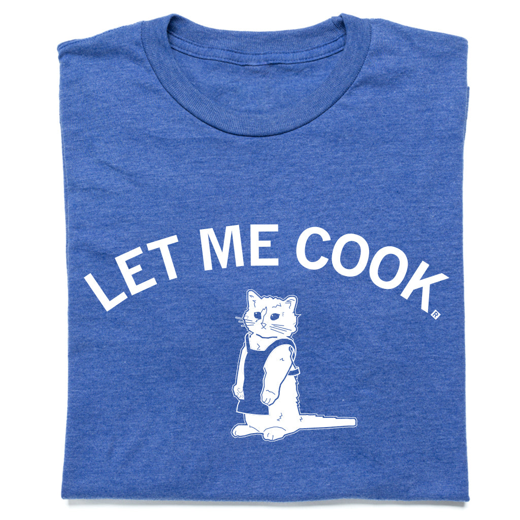 Heather royal blue t-shirt featuring the white text LET ME COOK above an illustration of a cat wearing an apron.