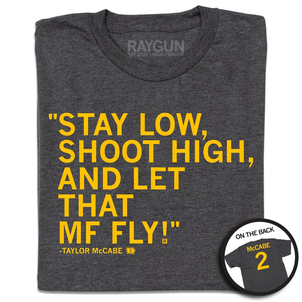 A folded charcoal t-shirt with gold ink text on the front that reads "Stay low, shoot high, and let that MF fly!" - Taylor McCabe." and the back is laid out like a jersey with "McCabe 2."