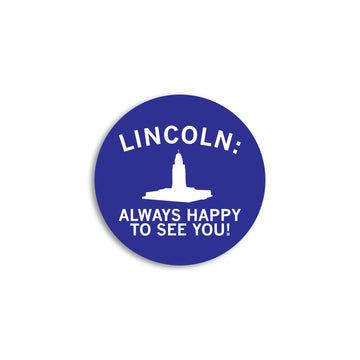 Circular blue RAYGUN vinyl sticker featuring a white silhouette of the Nebraska State Capitol building and the text LINCOLN: ALWAYS HAPPY TO SEE YOU!.