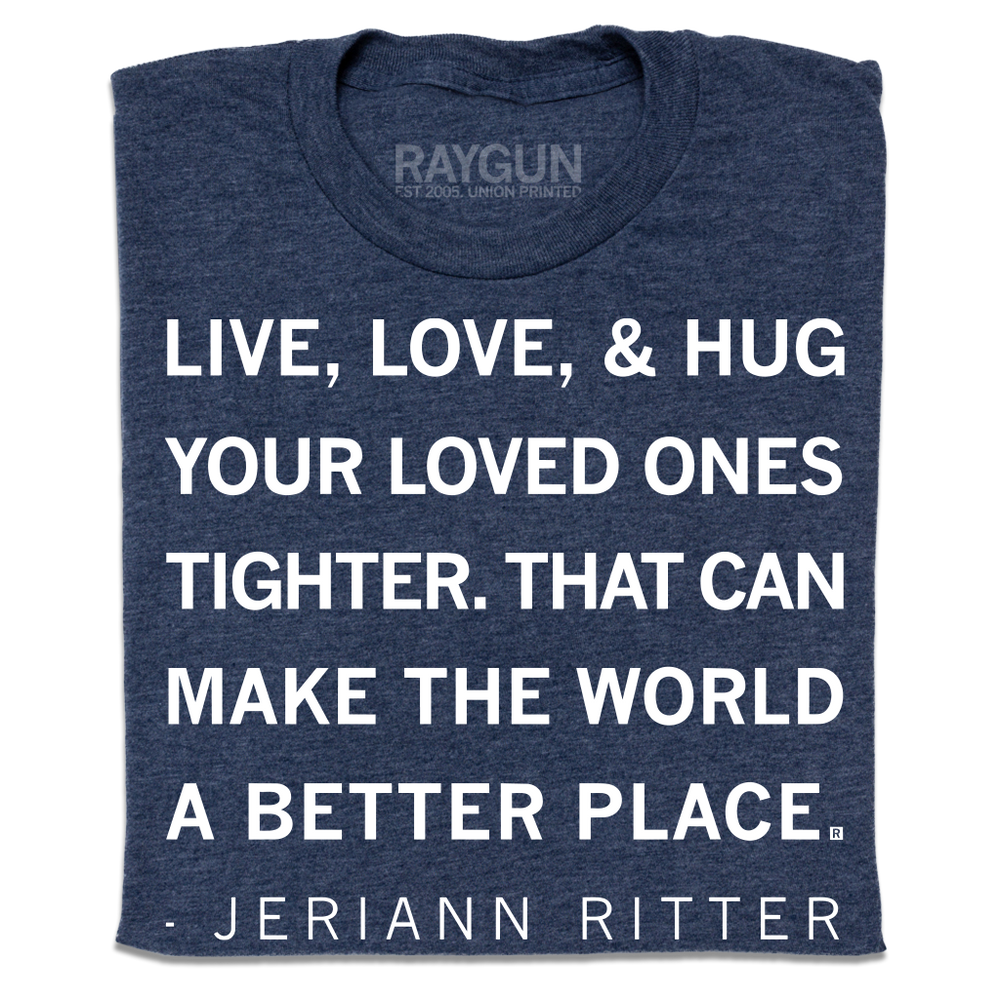 A folded heather navy t-shirt with white ink text that says, "Live, love, &amp; hug your loved ones tighter. That can make the world a better place. - Jeriann Ritter."