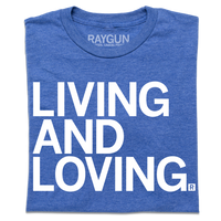 A folded heather royal blue t-shirt with large, left-aligned white ink text that reads "Living and Loving"