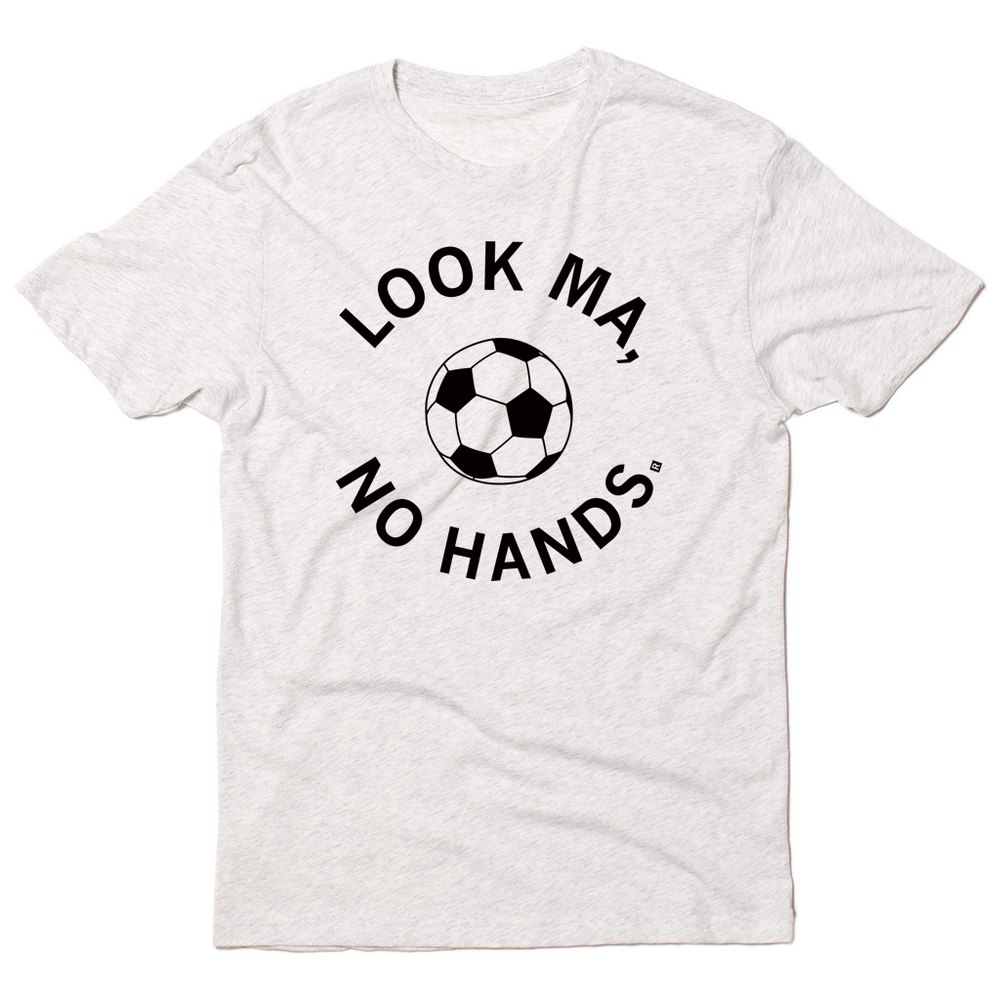A triblend heather white t-shirt with black ink. An illustrated soccer ball in the center is surrounded by curved text that reads "Look ma, no hands."