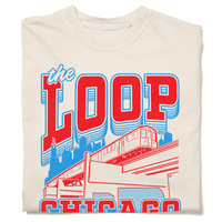 A folded ivory heavyweight t-shirt with Red and blue ink depicting the Chicago L train in front of the city skyline. Red text with blue outline reads "The Loop" above the image and "Chicago. Live, laugh, loop" below.