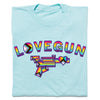 Heather purist blue Lovegun T-shirt featuring the word LOVEGUN above a stylized gun graphic, both in rainbow pride and progress pride flag color schemes.
