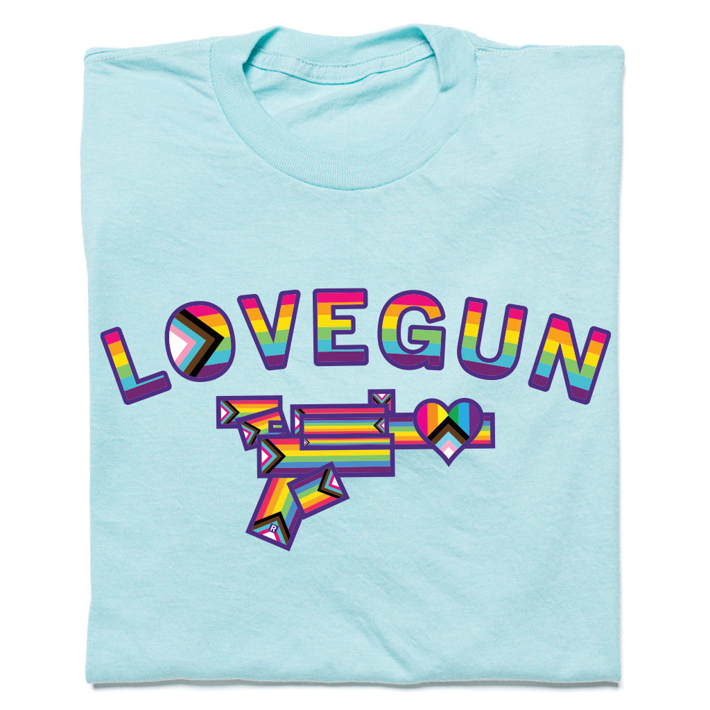 Heather purist blue Lovegun T-shirt featuring the word LOVEGUN above a stylized gun graphic, both in rainbow pride and progress pride flag color schemes.