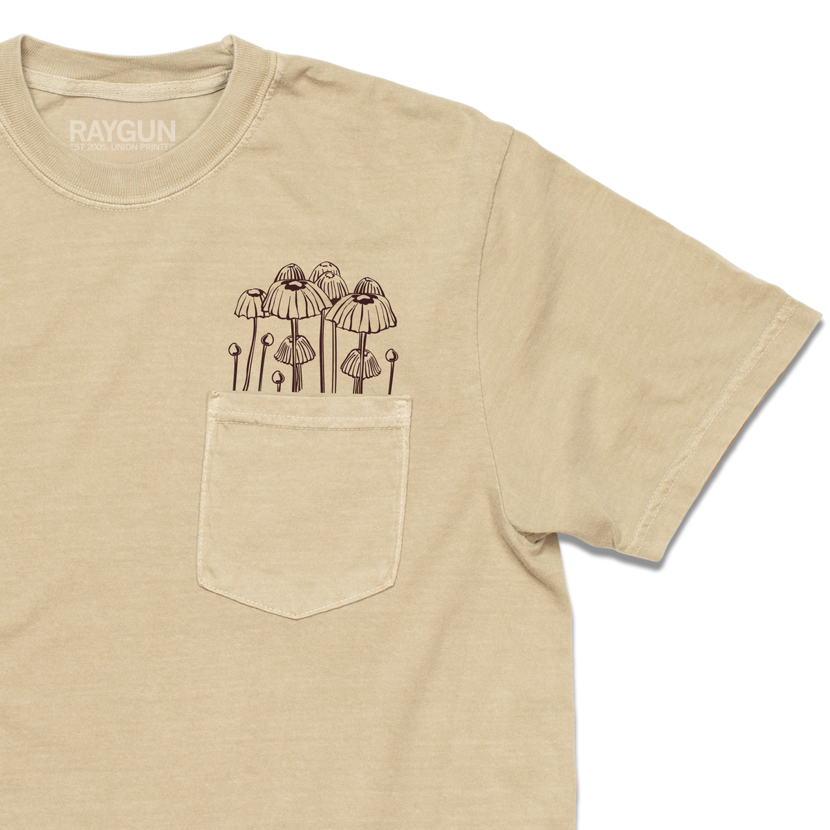Garment-dyed khaki t-shirt with a chest pocket featuring a brown line drawing of mushrooms growing out of the top.