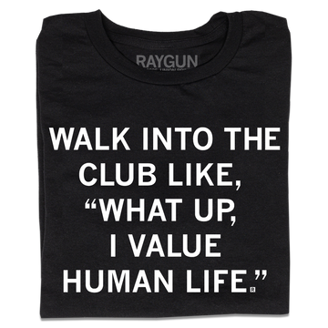 A folded black t-shirt with centered white ink text that says, "WALK INTO THE CLUB LIKE "WHAT UP, I VALUE HUMAN LIFE."