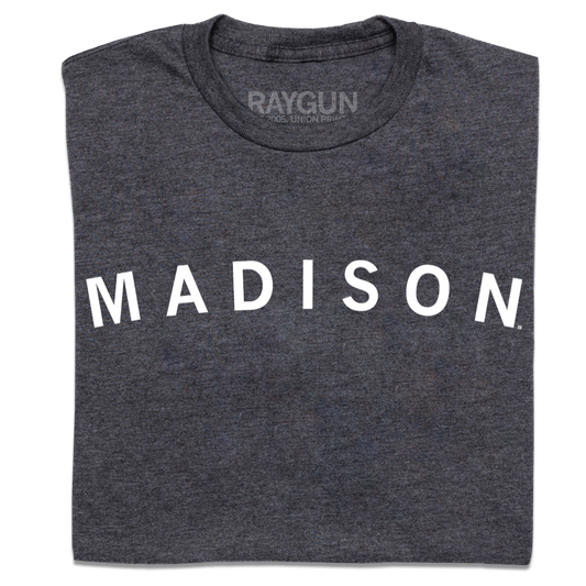 Charcoal gray t-shirt with MADISON printed in large white capital letters across the front, representative of Madison, Wisconsin.