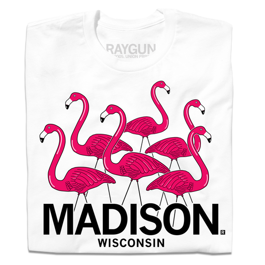 A folded white t-shirt with an illustration of six lawn flamingos looking in different directions above "Madison Wisconsin" printed in black ink.