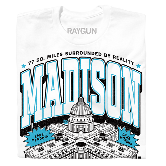 White Madison WI t-shirt featuring the Wisconsin State Capitol, the text MADISON and 77 SQ. MILES SURROUNDED BY REALITY, and labels for Lake Mendota and Lake Monona. This union made shirt is printed in the USA.