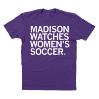 Purple shirt with left aligned white ink that reads "Madison watches women's soccer"