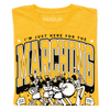 Heather mellow yellow t-shirt with a screen print reading I’m just here for the marching above an illustration of a marching band and the phrases On my count and Check step.