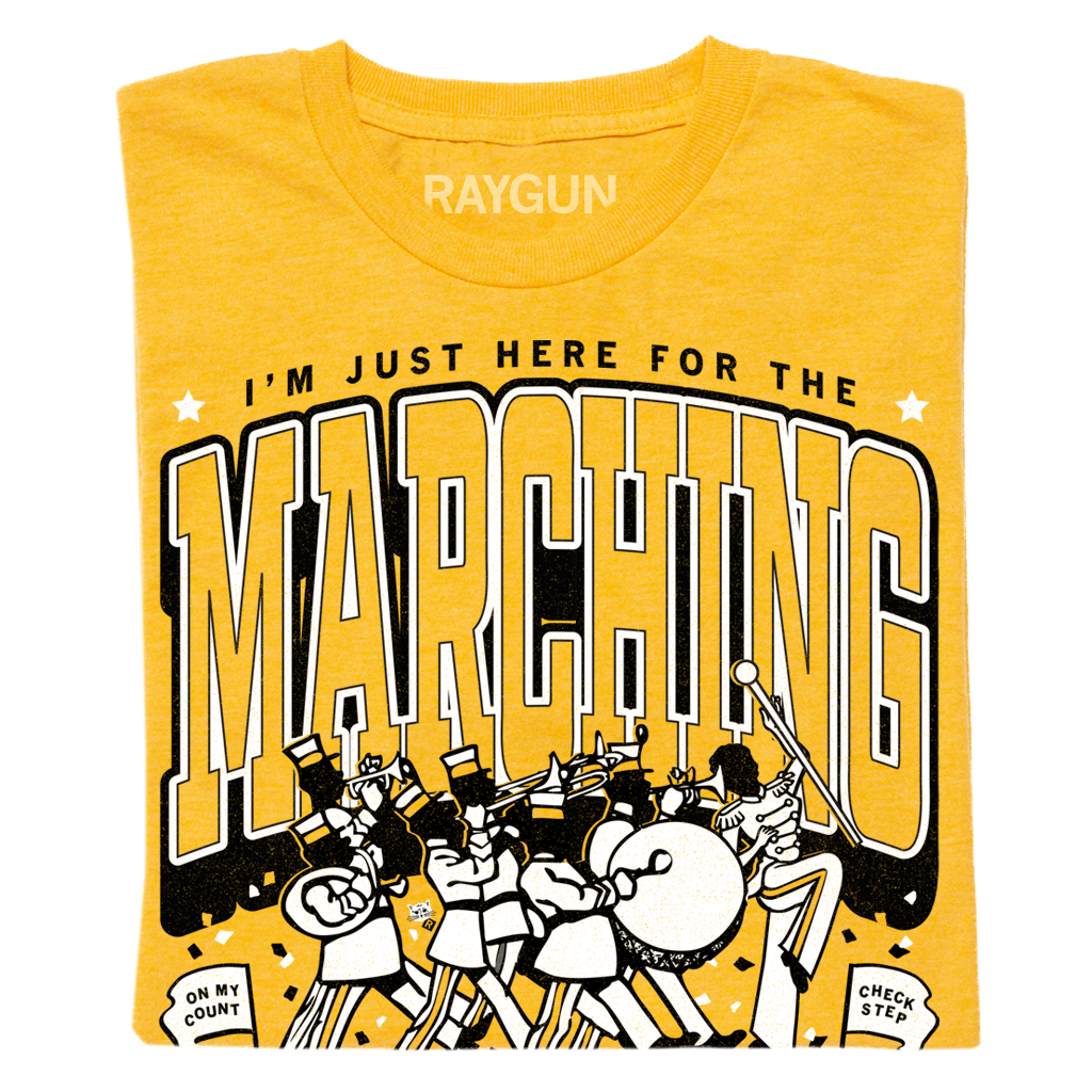 Heather mellow yellow t-shirt with a screen print reading I’m just here for the marching above an illustration of a marching band and the phrases On my count and Check step.