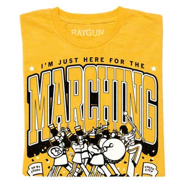 Heather mellow yellow t-shirt with a screen print reading I’m just here for the marching above an illustration of a marching band and the phrases On my count and Check step.
