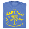 A folded blue heavyweight t-shirt with bright yellow ink. The center is an illustration of a martini glass with tiny basketballs on a toothpick in place of olives. Curved text above says "The MARTINIS!" and smaller fond below the image adds "THE KATE MARTIN FAN CLUB." There's also a bouncing basketballs, scatters stars, and other accents.
