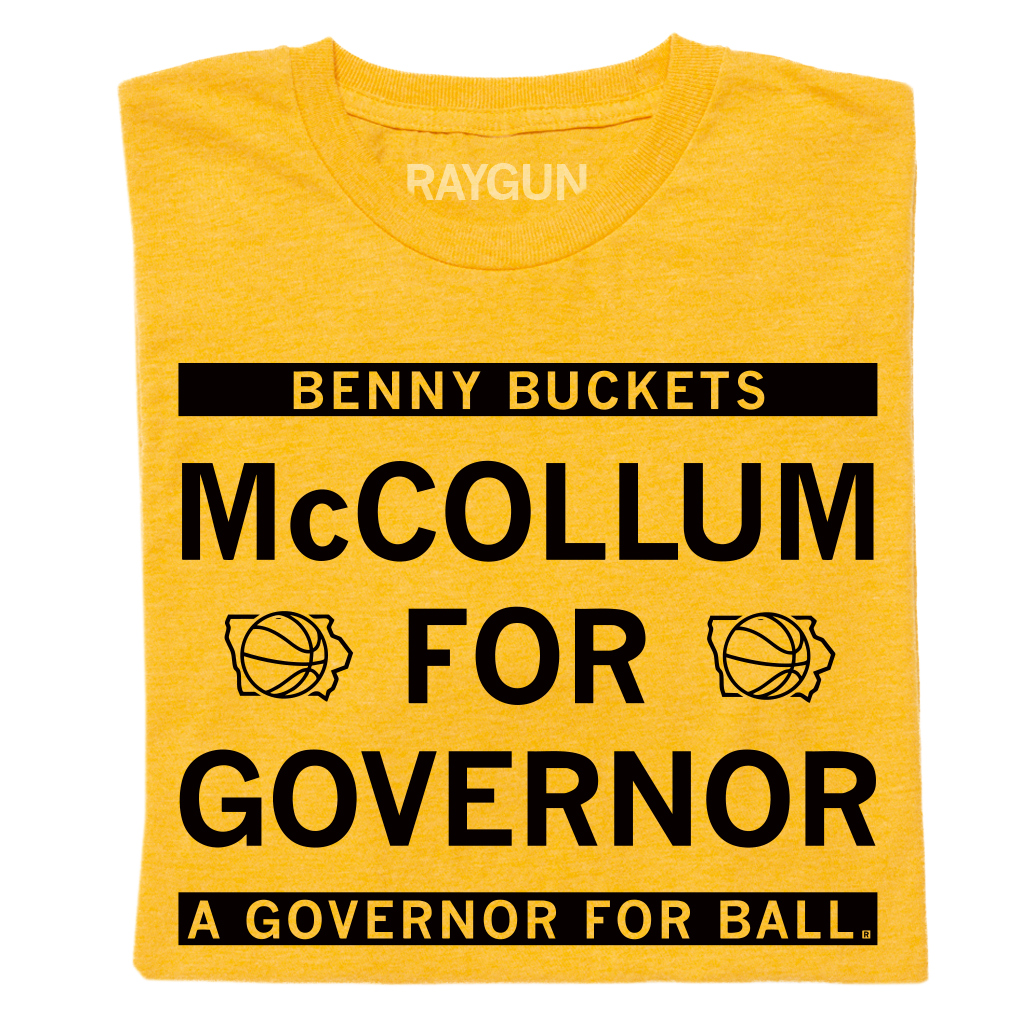 A folded heather gold shirt with black ink text that reads "Benny Buckets. McCollum for Governor. A Governor for ball."