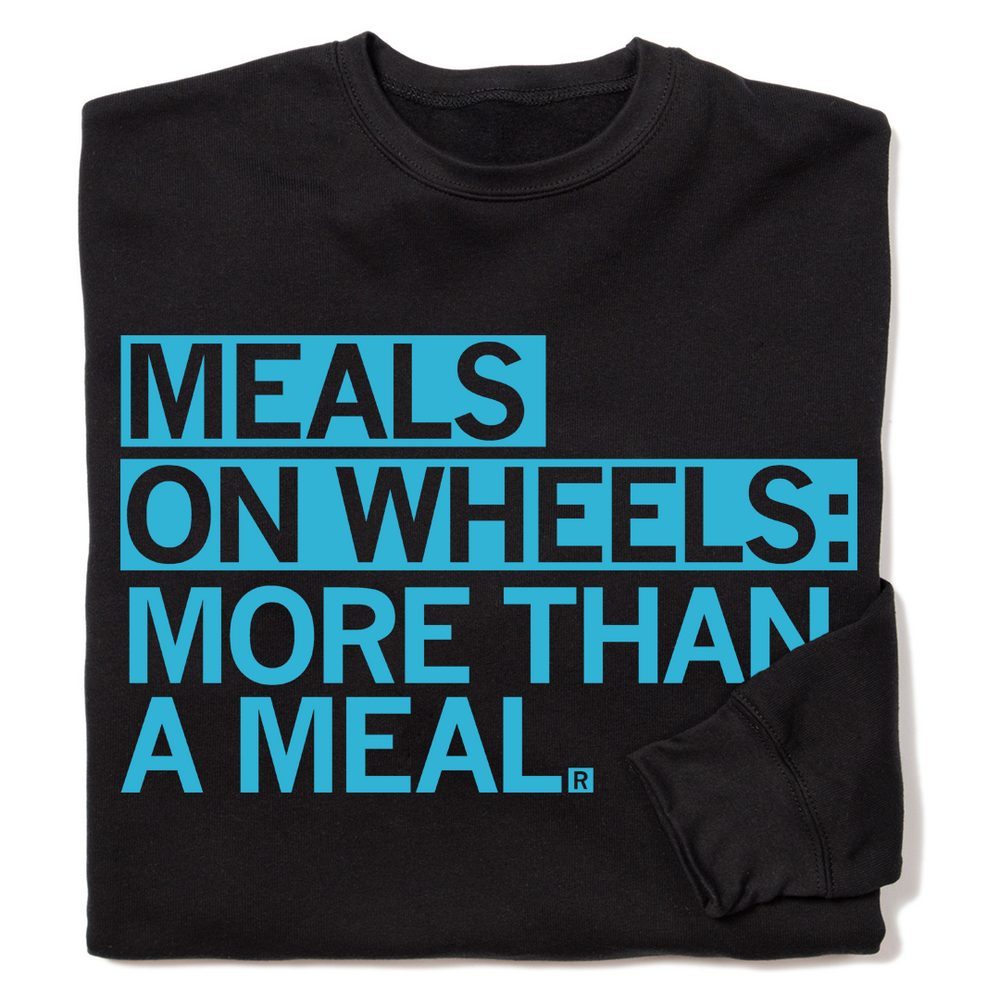 A folded black crew sweatshirt with left-aligned bright blue text that reads "Meals On Wheels: More than a meal" in all caps.